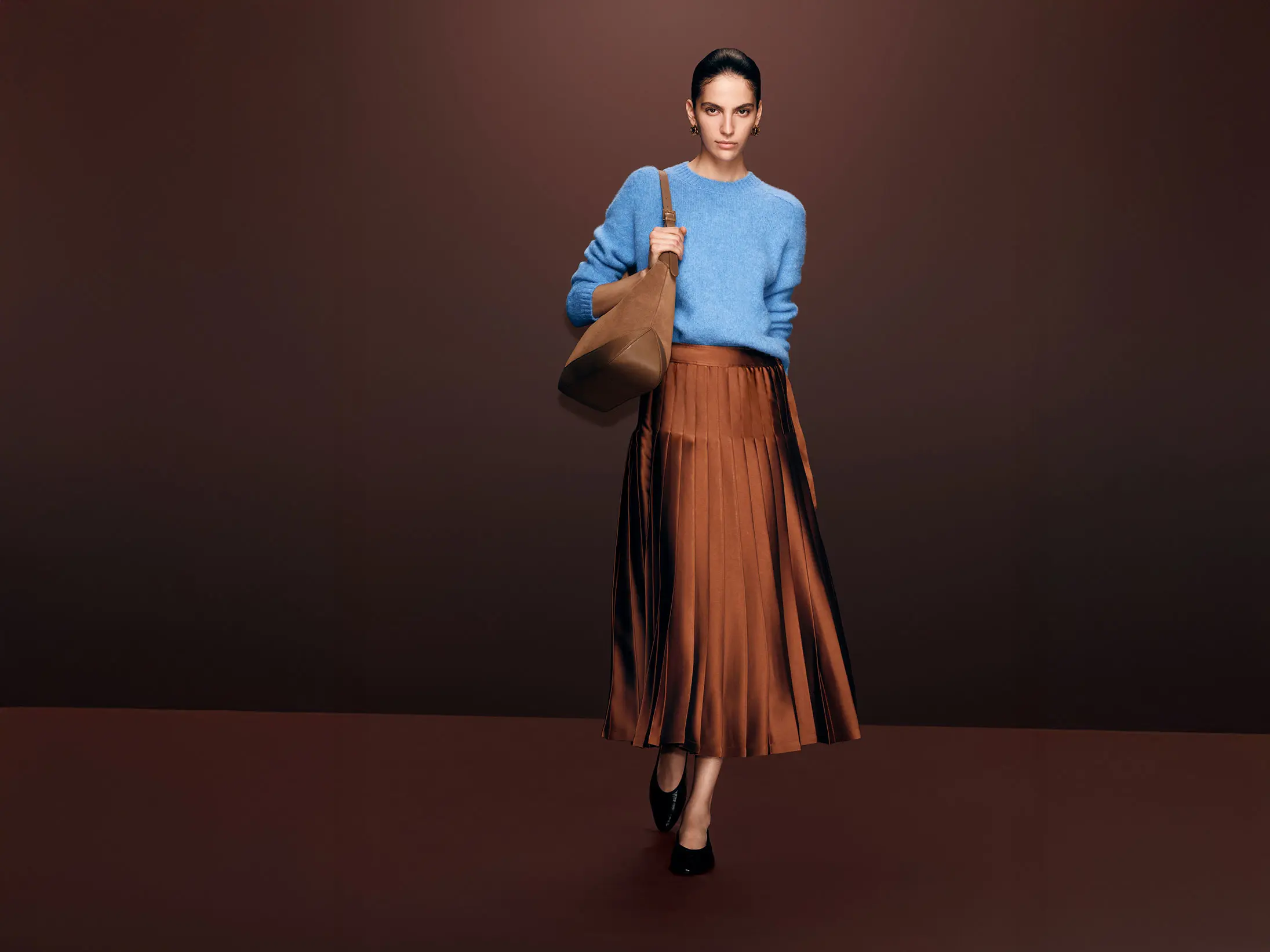 Woman wearing blue sweater and satin skirt from Autograph