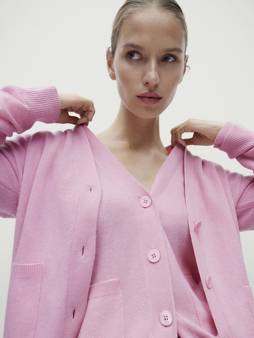 Woman wearing pink layered V-neck cardigans