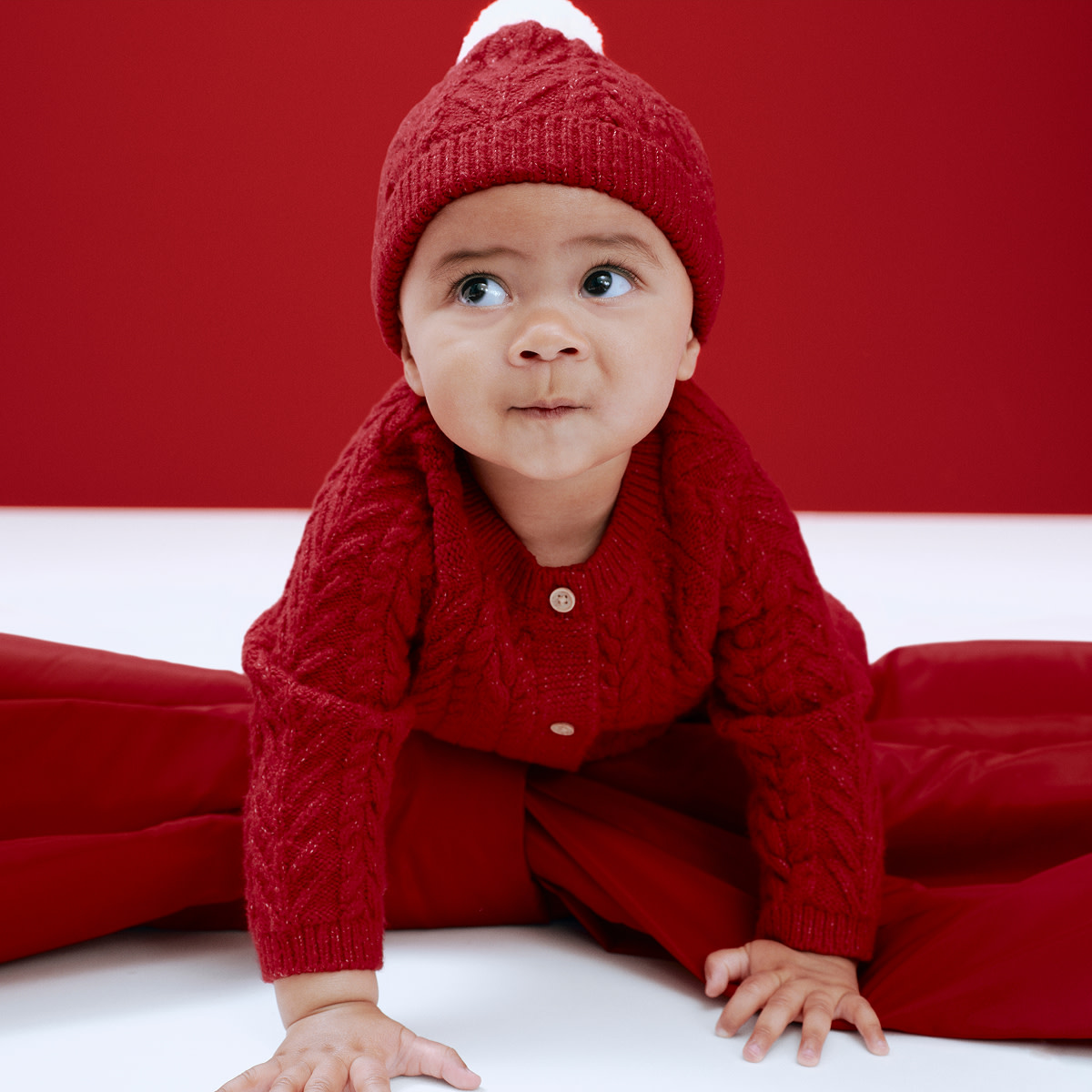 Baby wearing red cable-knit outfit