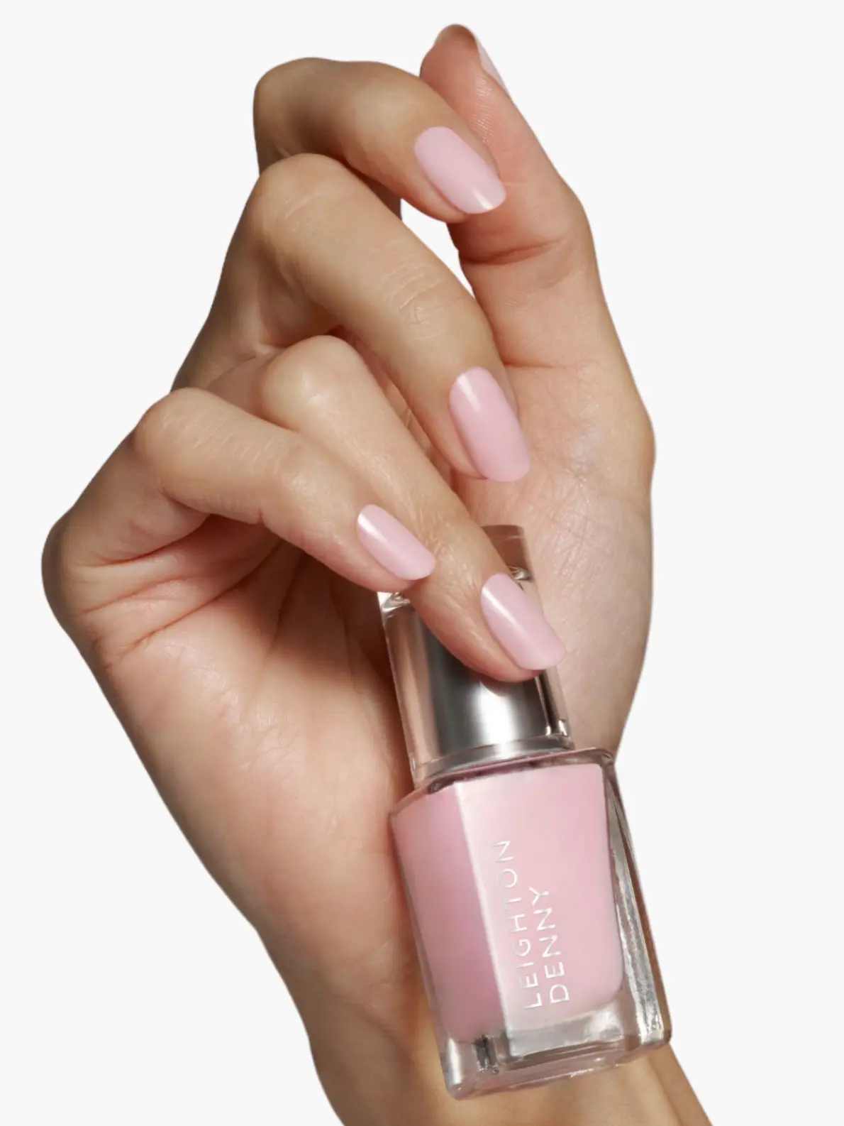 Hand with pink painted nails holding pink nail polish