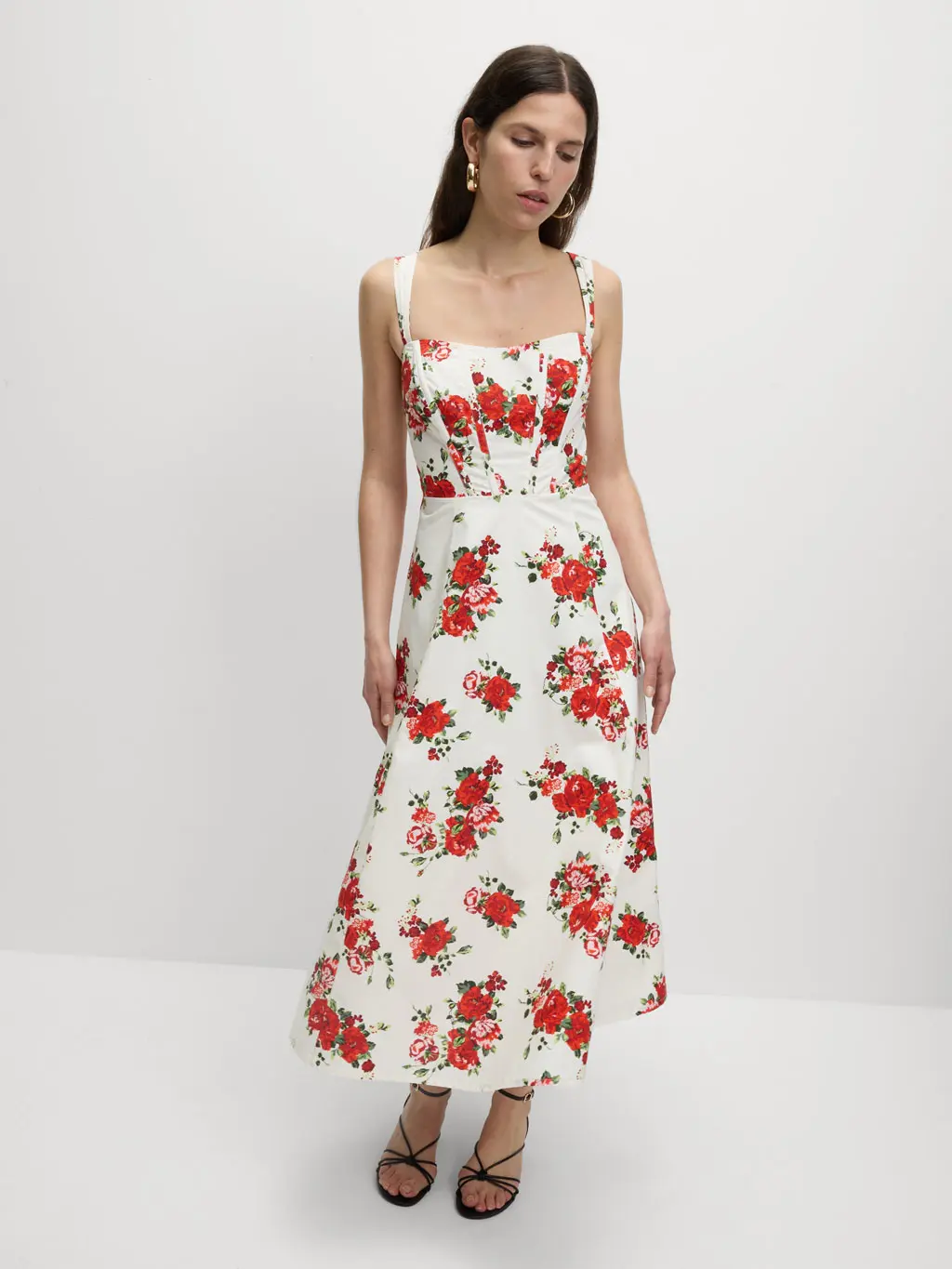 Woman wearing a white corset dress with red rose print