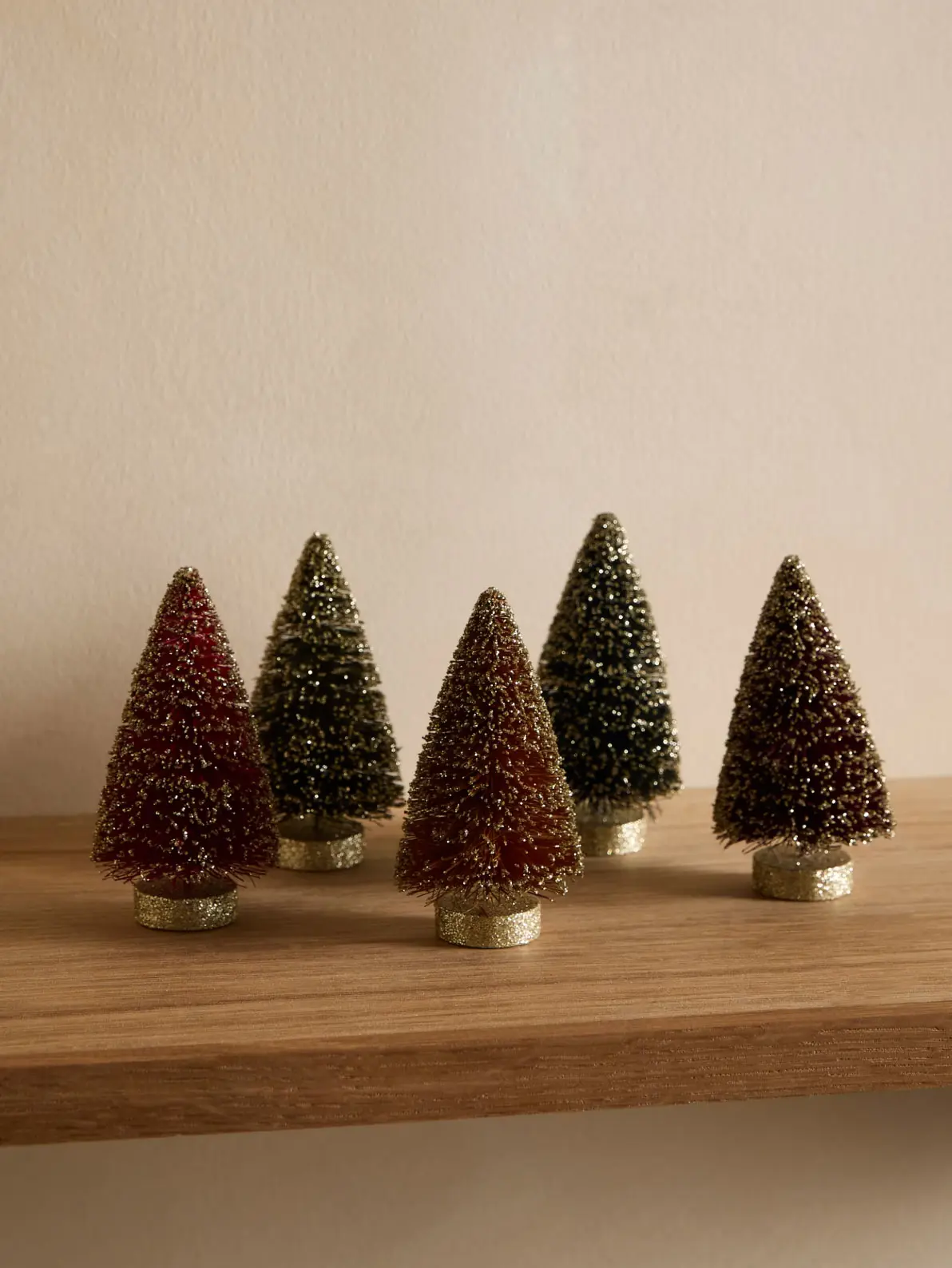 Image of five small tree decorations in red and green