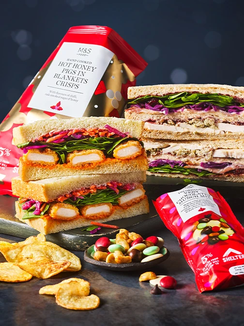 Christmas sandwiches stacked on top of each other with bags of crisps