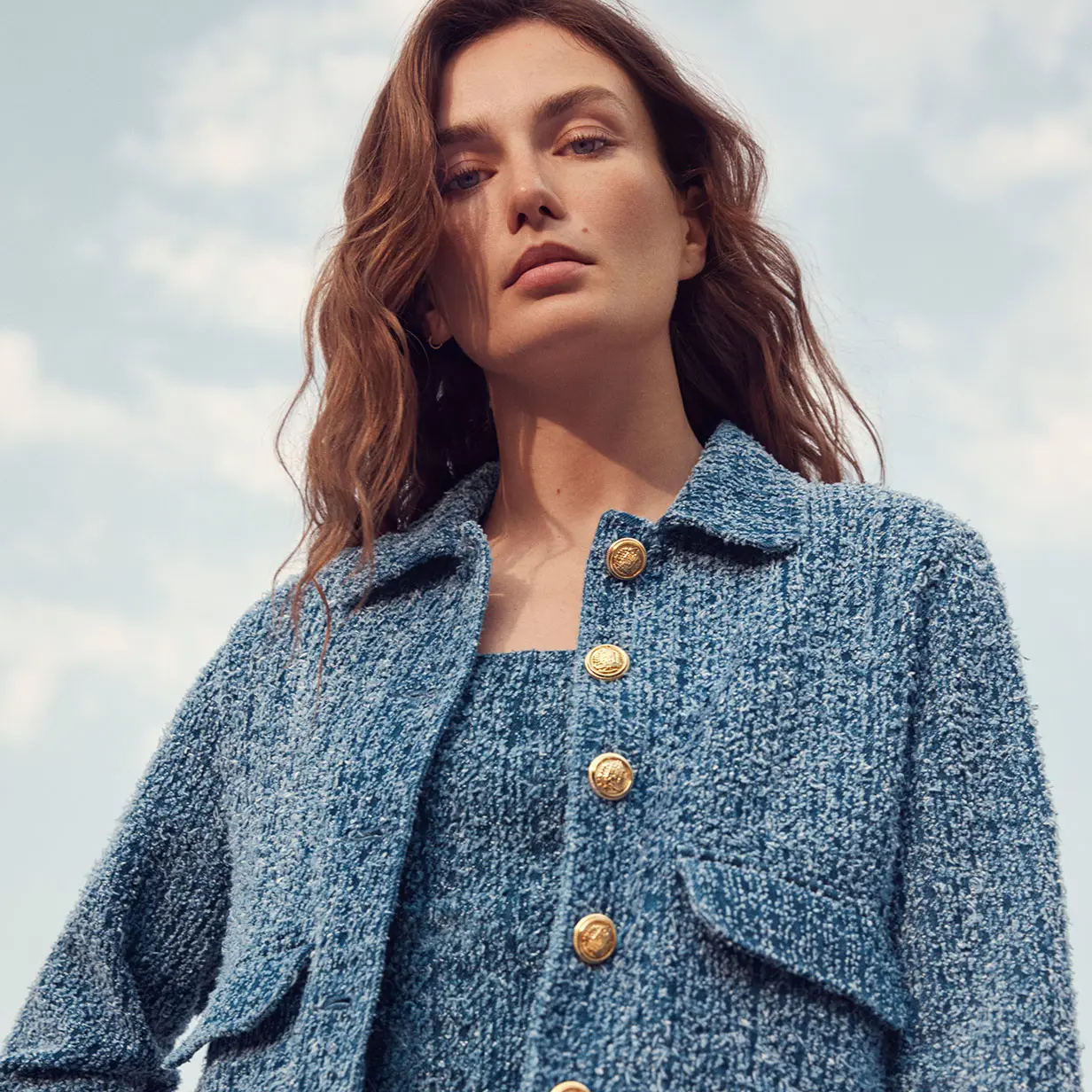 Woman wearing blue tweed-style jacket and matching dress