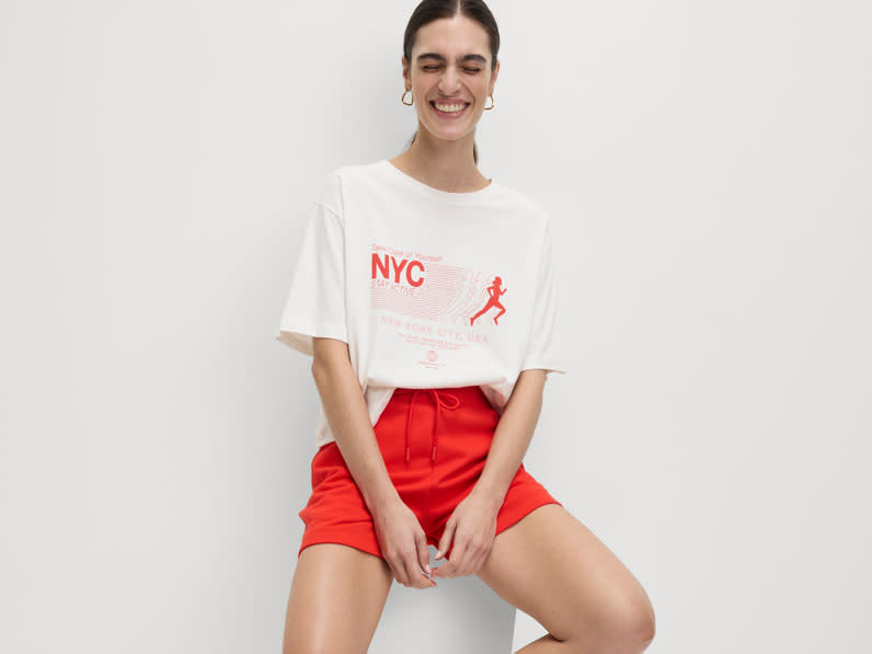 Woman wearing a white T-shirt with a red print, and red shorts