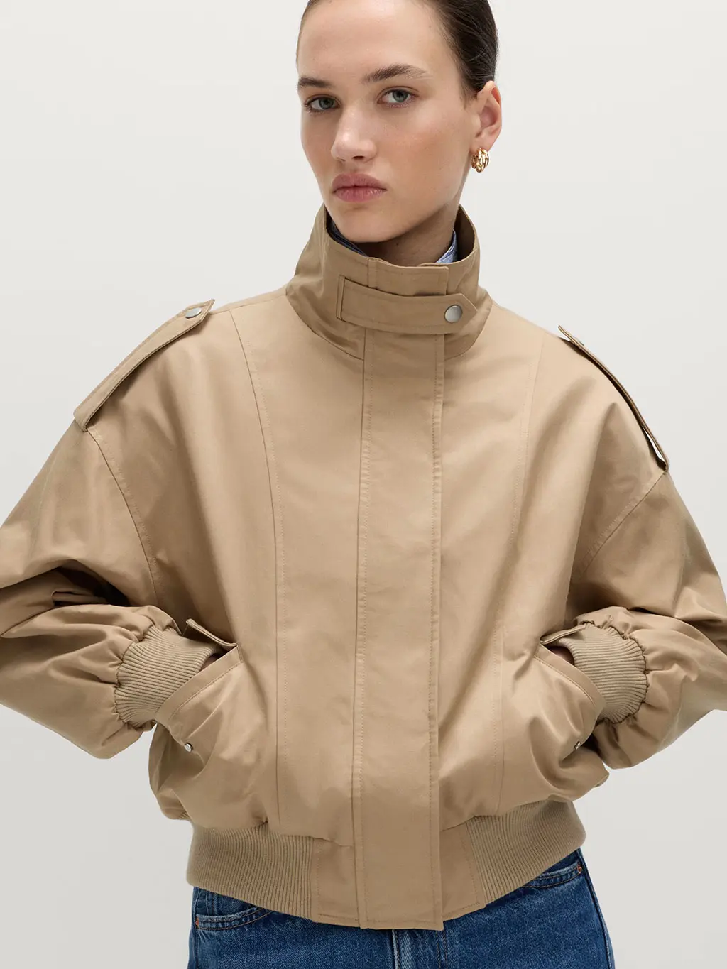 Woman wearing a funnel-neck jacket with blue jeans