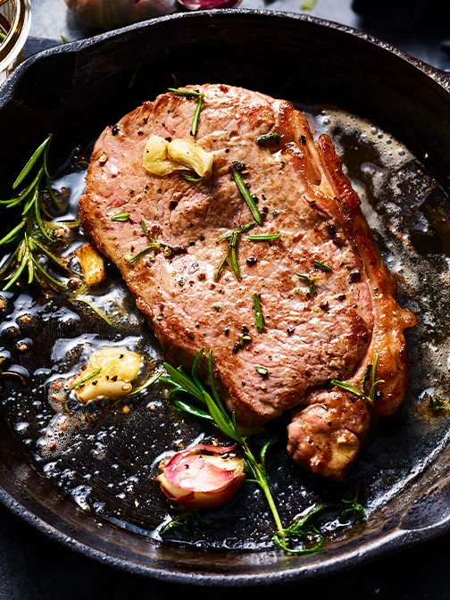 steak frying in a pan