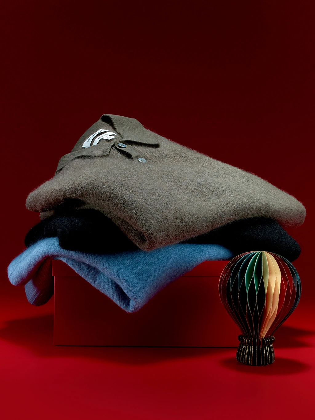 Blue and grey men's jumpers folded in a pile.