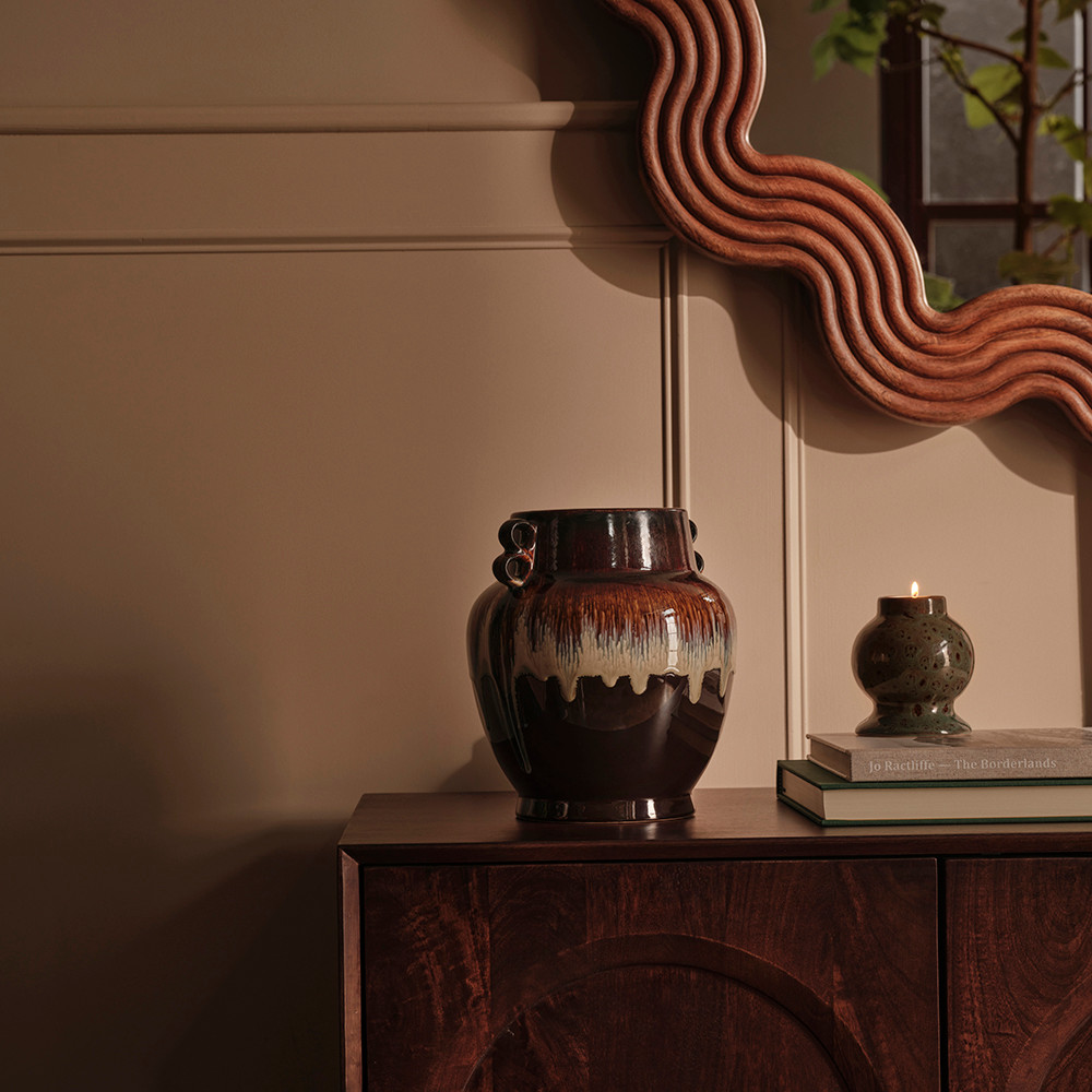 Cabinet styled with ceramics, books and a candle holder