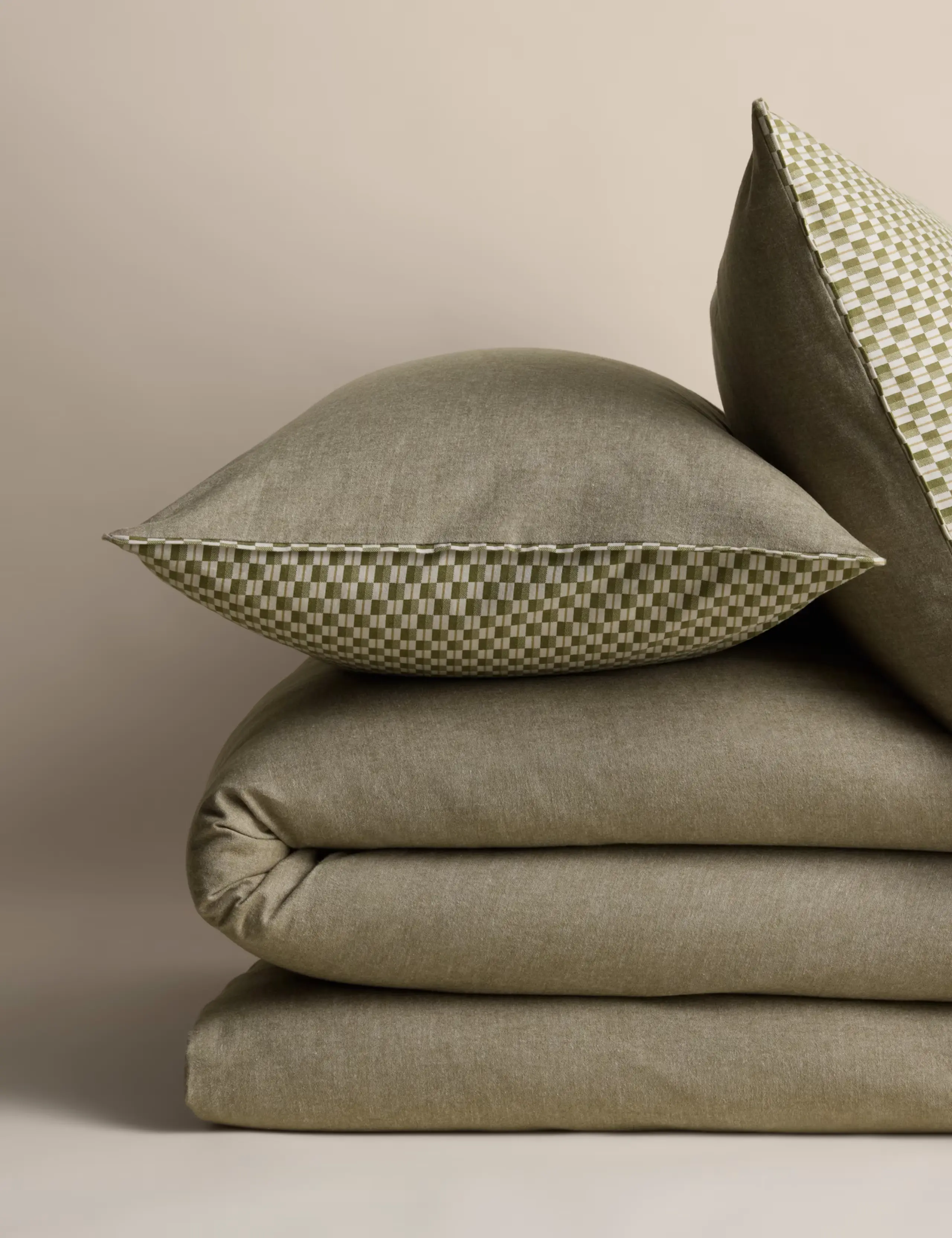 Green bedding set with two pillows, duvet cover and reverse checked pattern.