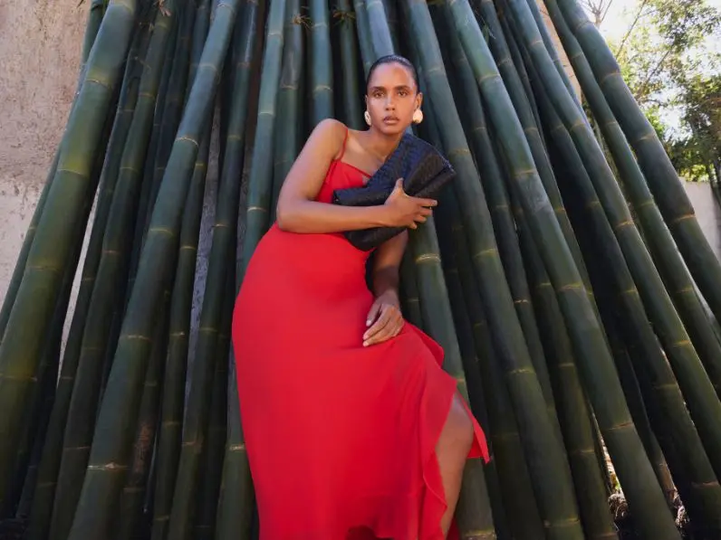 A woman wears a bright red cowl-neck slip dress
