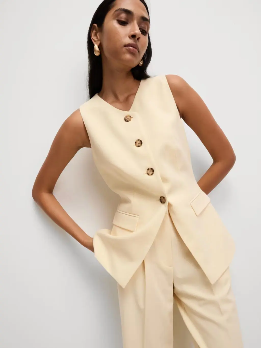 Woman wearing a pale yellow waistcoat and matching trousers