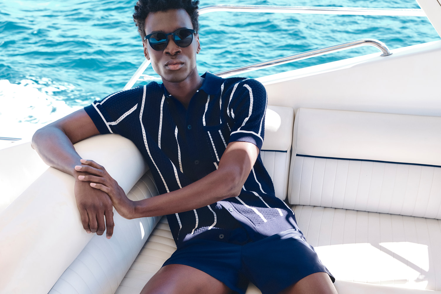 Man wearing a blue and white striped shirt and a pair of blue shorts on a boat