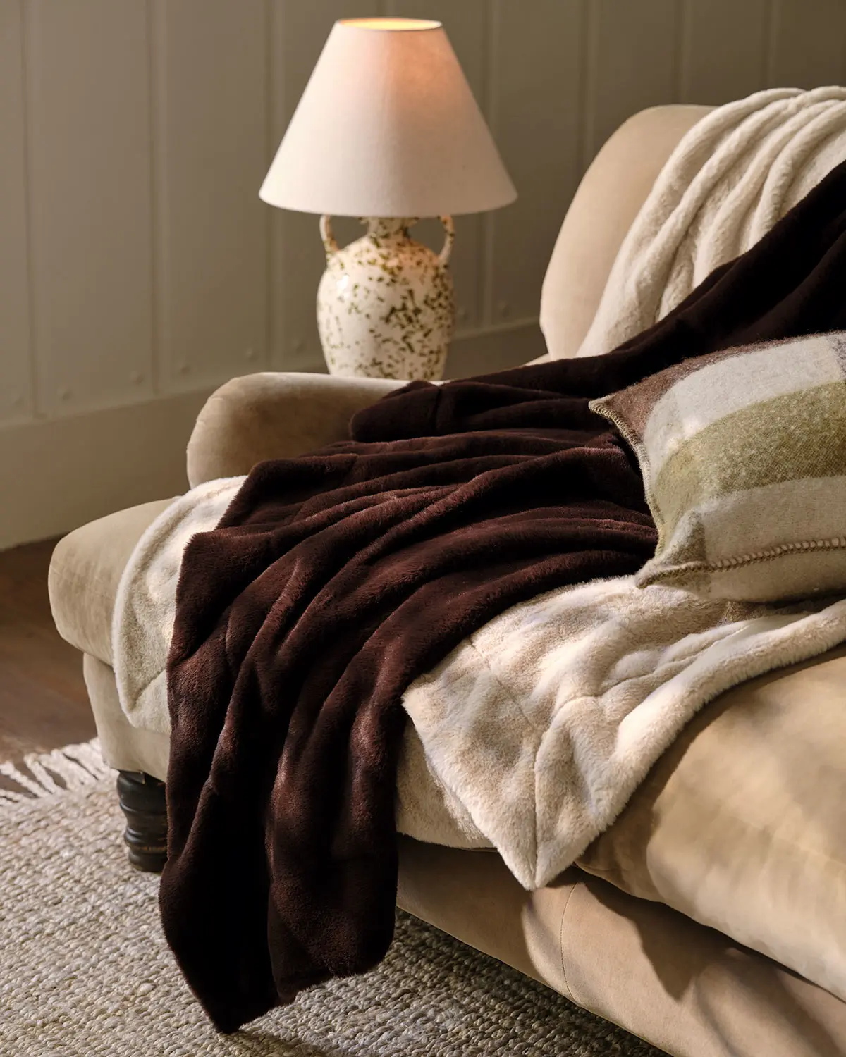 Sofa draped with faux fur and fleece throws