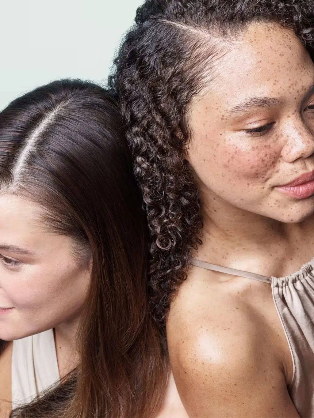 Woman with straight hair beside a woman with curly hair