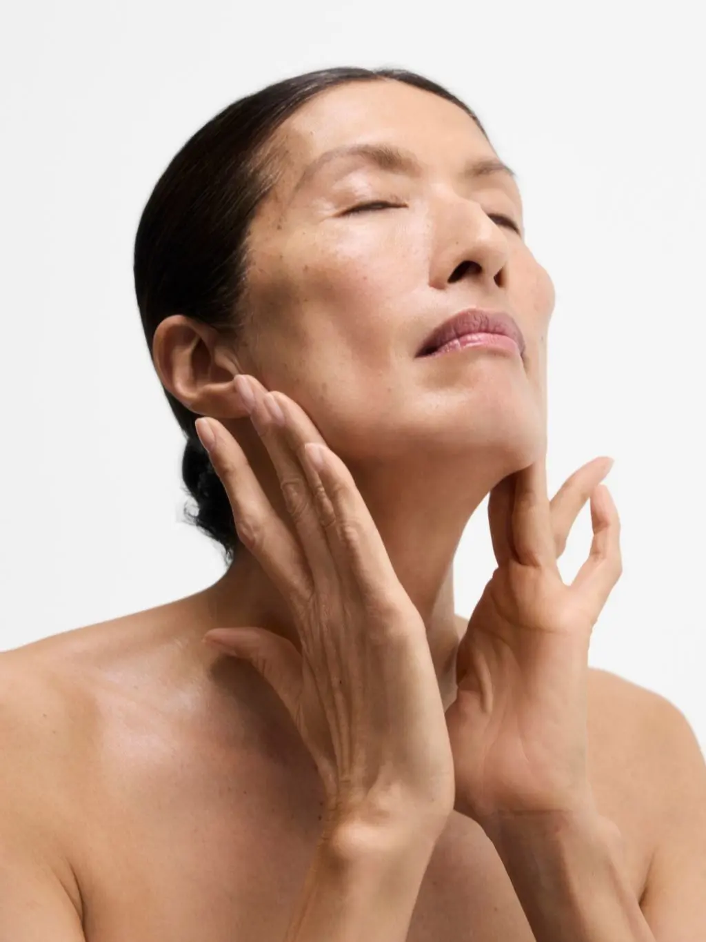 A woman moisturising her face