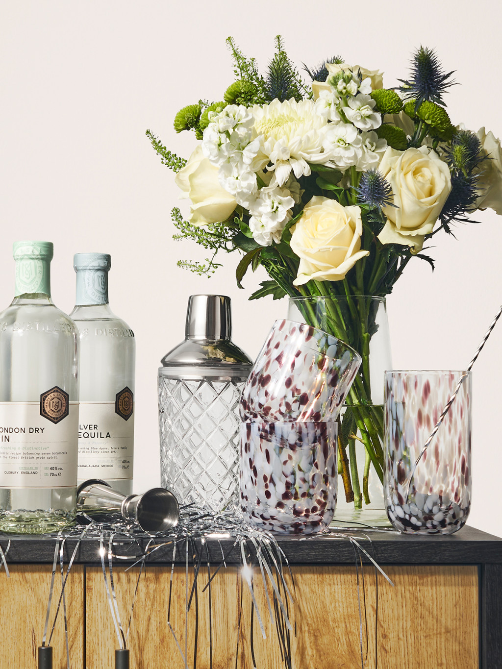Flowers and glasses with a cocktail shaker. Explore wedding gift ideas