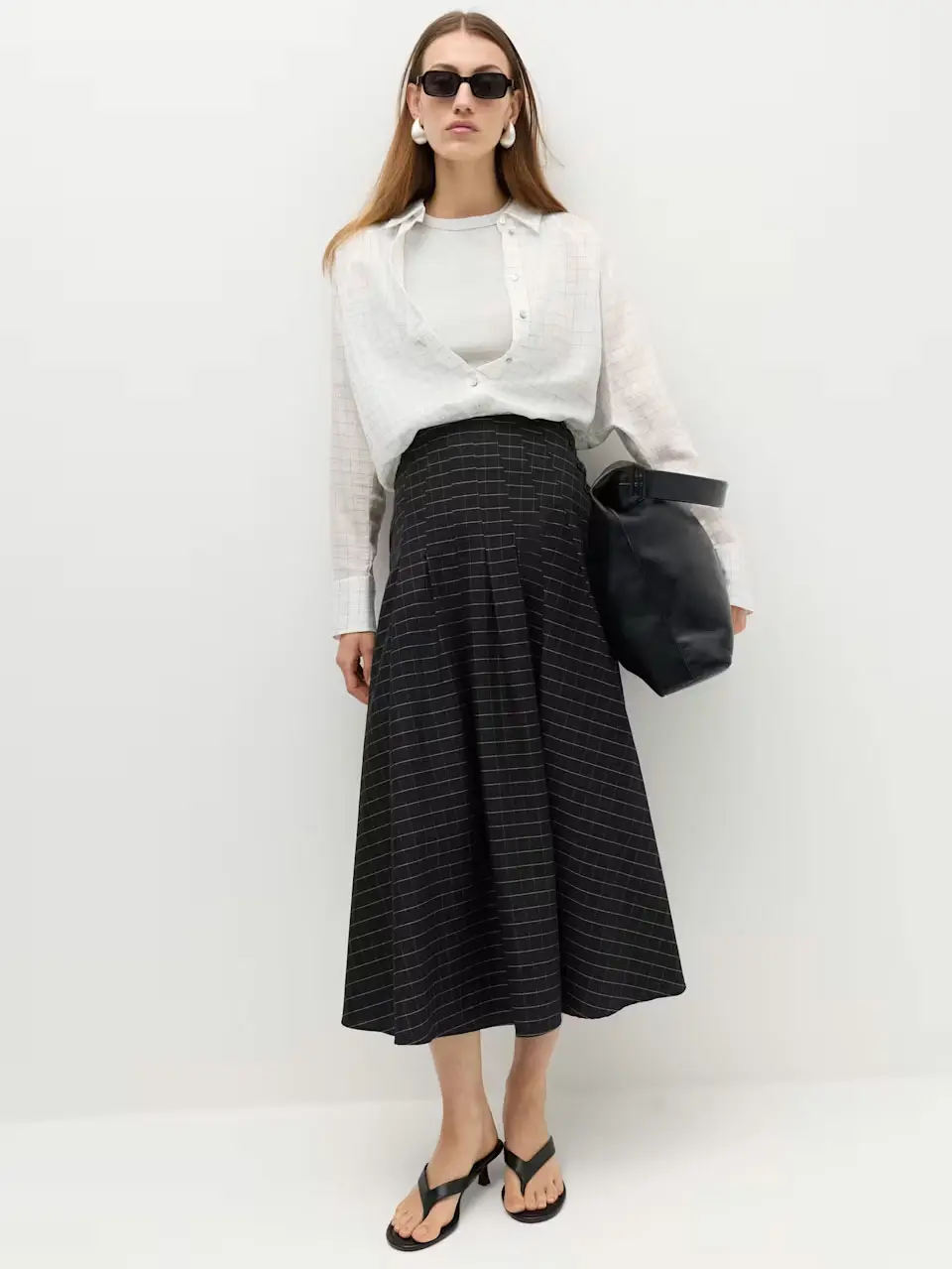 Woman in black midi skirt and white shirt