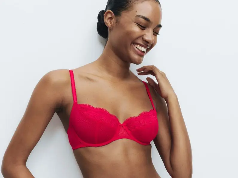 A woman wears a bright red balcony bra by M&S
