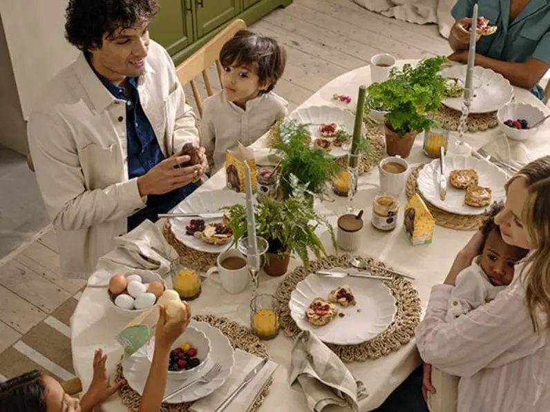 A family sit around a table decorated for Easter
