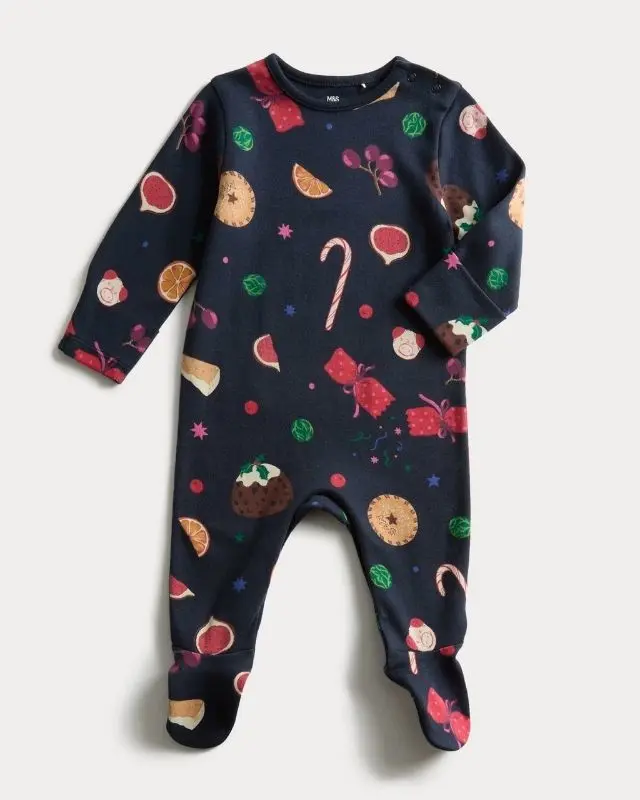 A baby sleepsuit covered in Christmas design