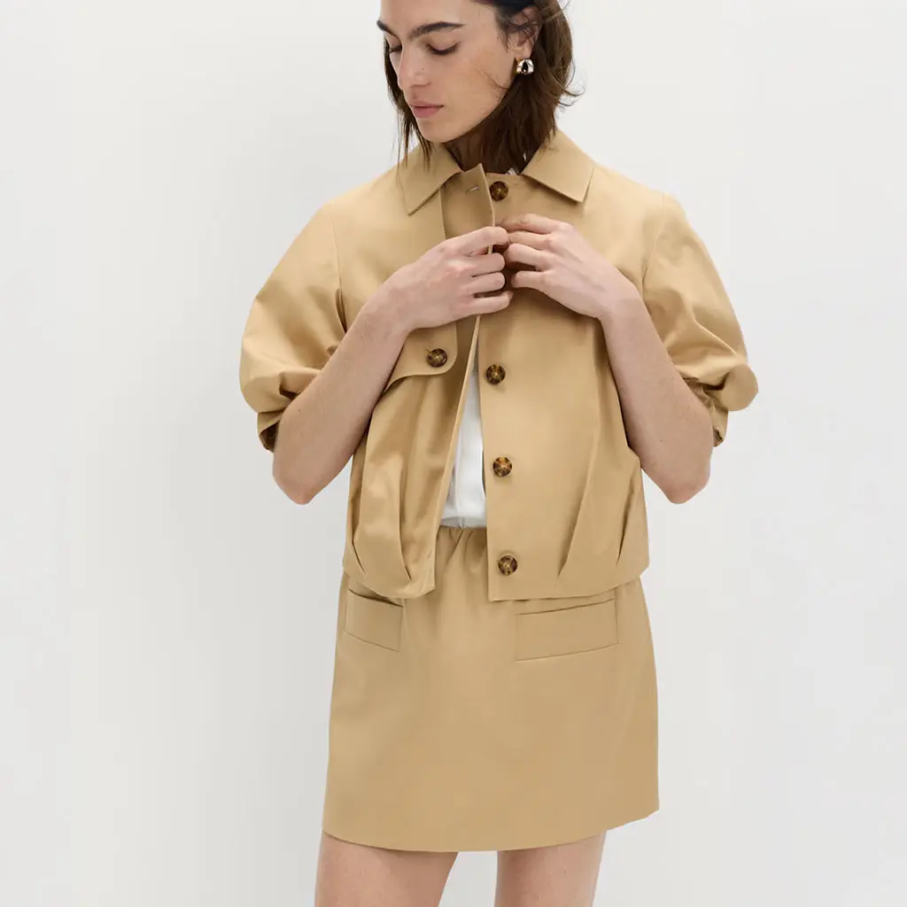 Woman wearing a balloon-sleeve jacket with a white shirt and matching skirt