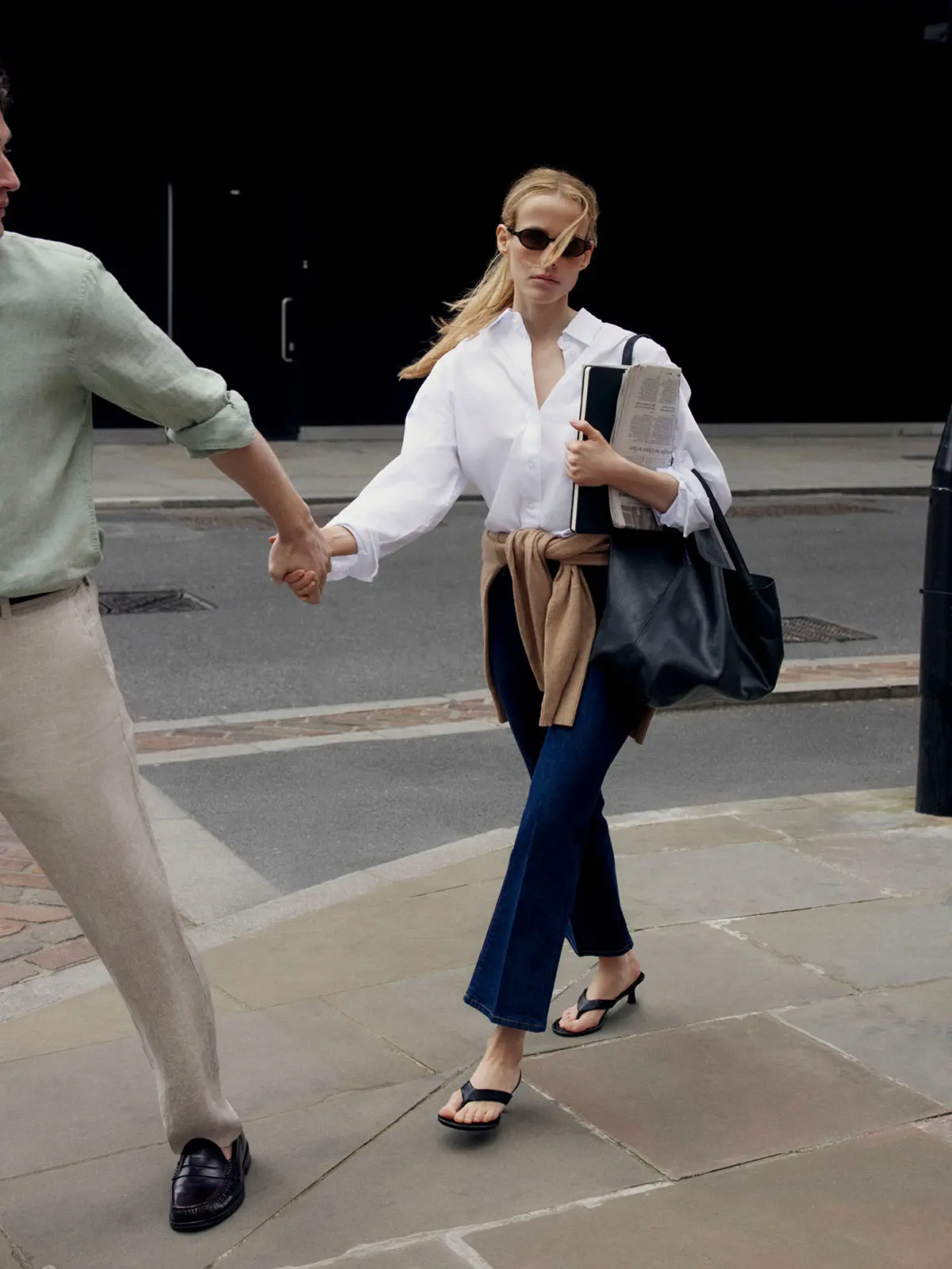 Woman wearing white shirt, blue jeans and black kitten heels 