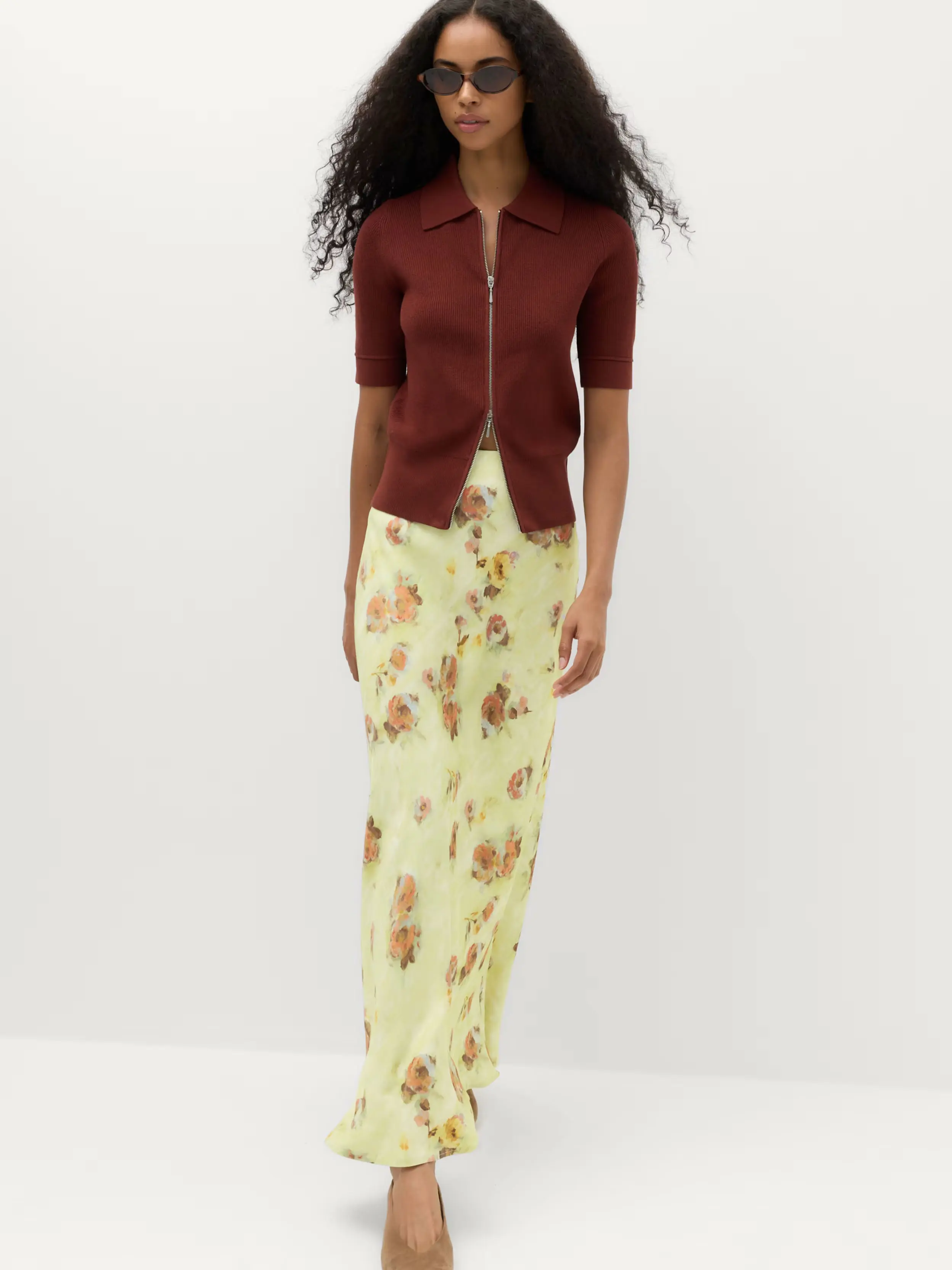 Woman in floral print skirt and maroon top