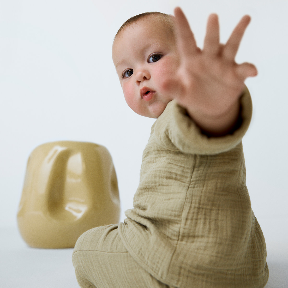 Baby wearing sage green romper
