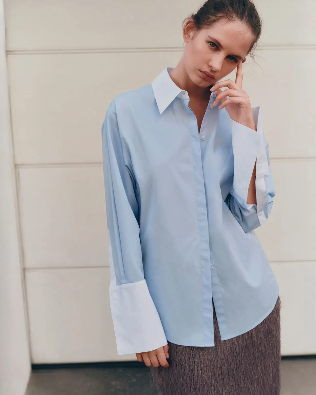 Woman wearing blue shirt with oversized contrast cuffs
