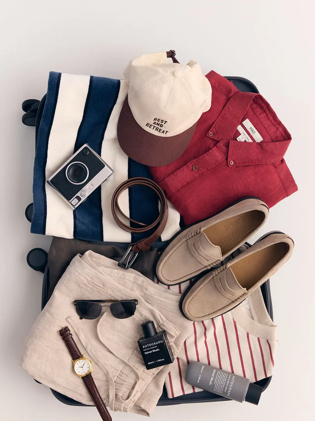 Suitcase full of men's holiday essentials