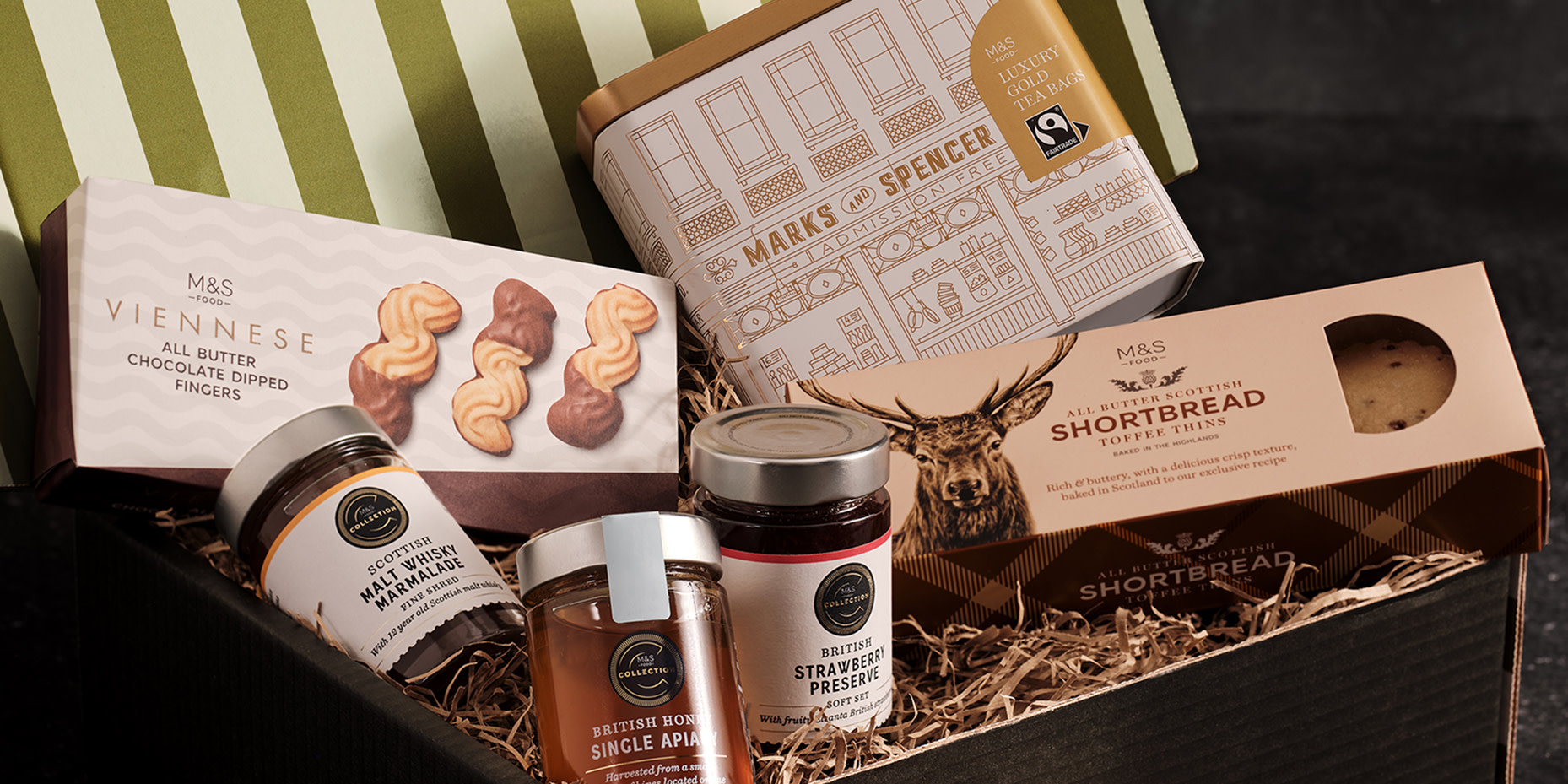 Open gift box revealing content including tea, biscuits and jams