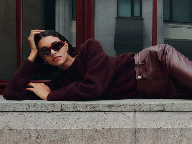 Woman wearing burgundy jumper & leather trousers