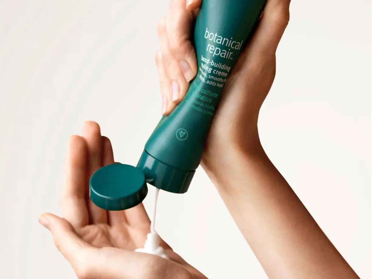 Woman squeezing haircare product into hand 