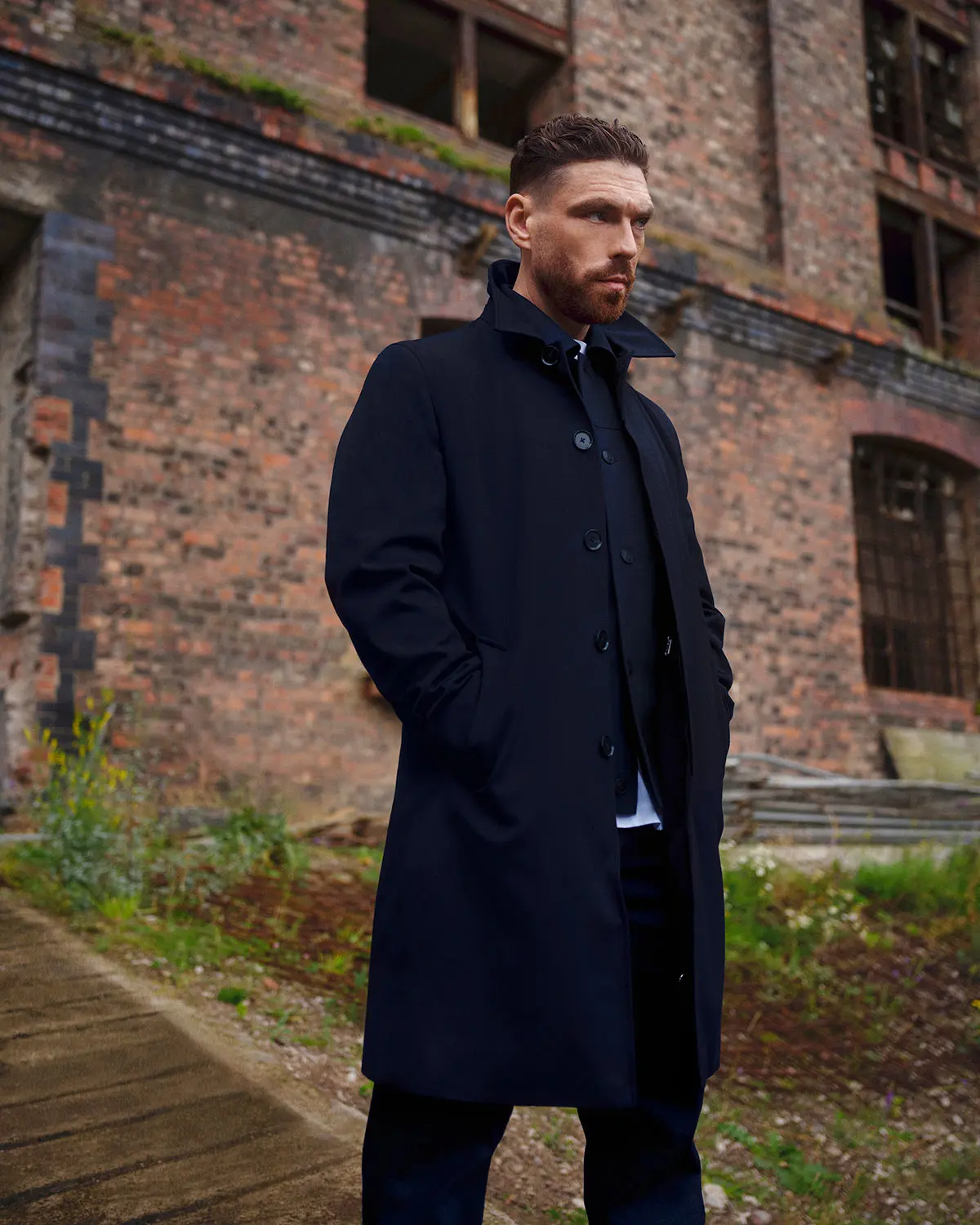 James Nelson Joyce wearing a navy coat by Autograph