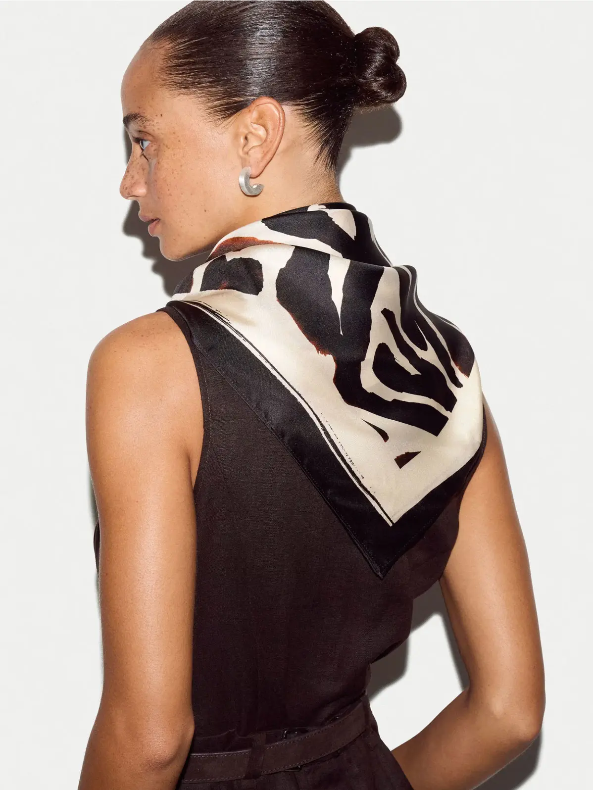 Woman wearing animal-print scarf tied around the neck