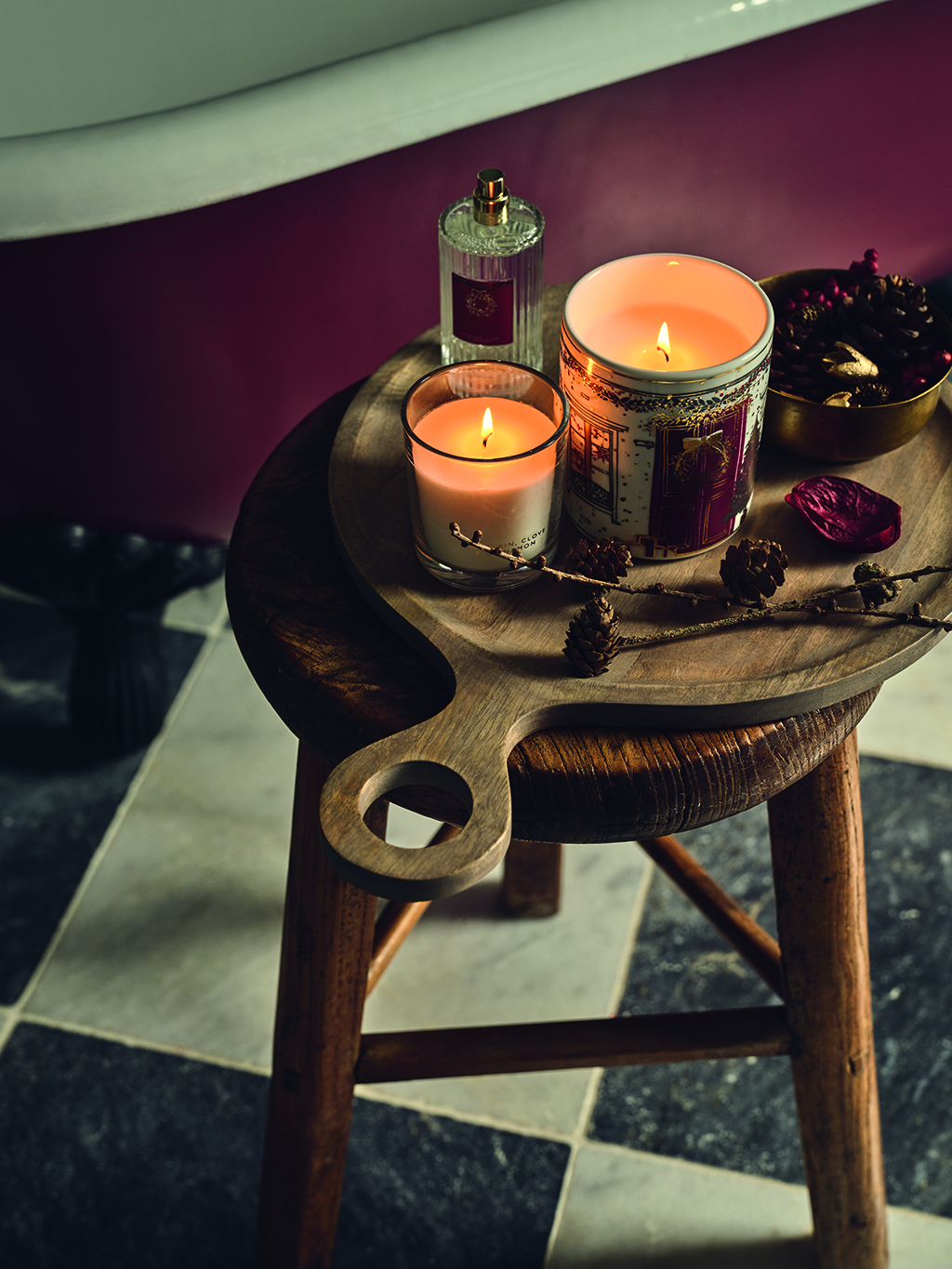 Assorted candles and Christmas home fragrance on a wooden stool