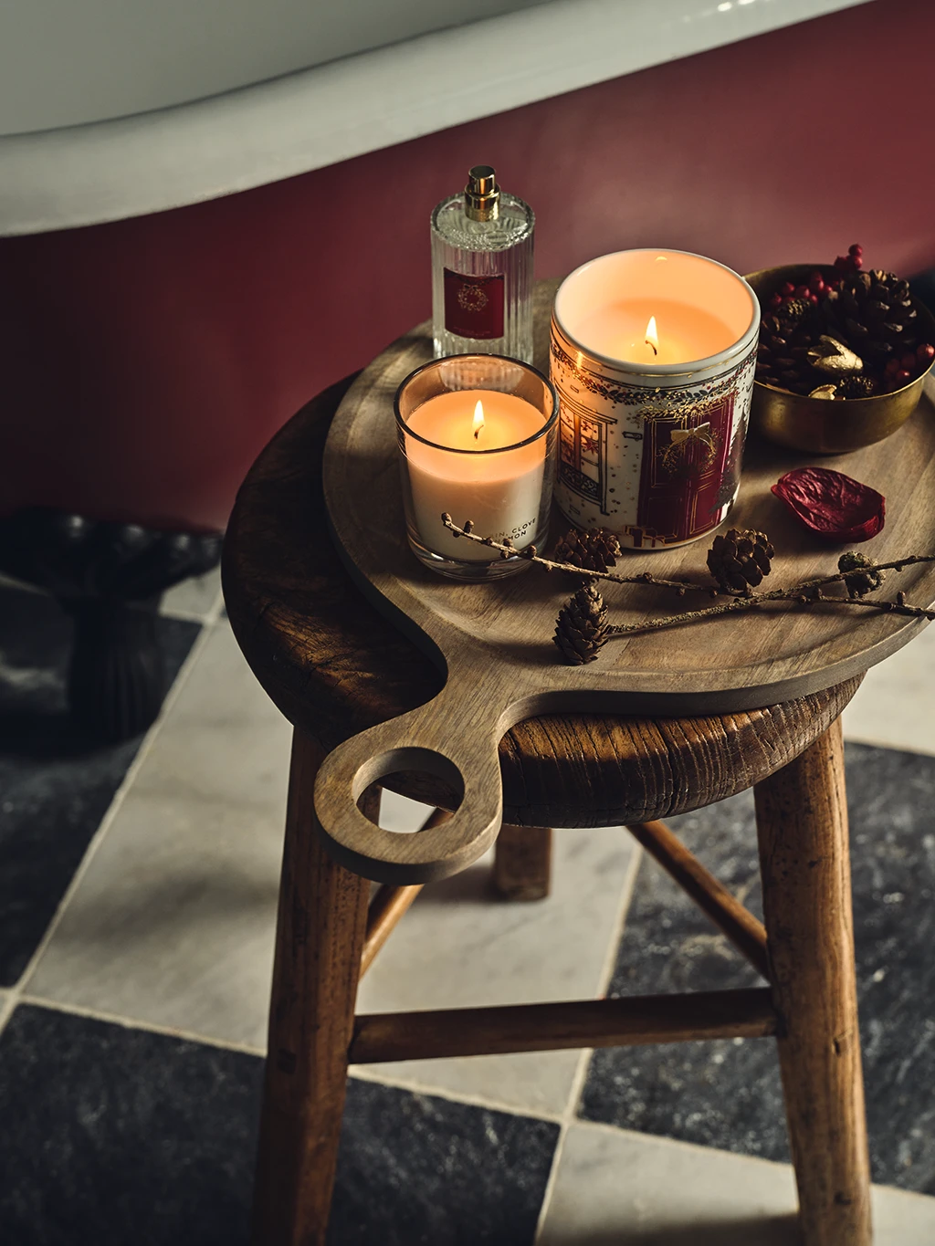 Assorted candles and Christmas home fragrance on a wooden stool