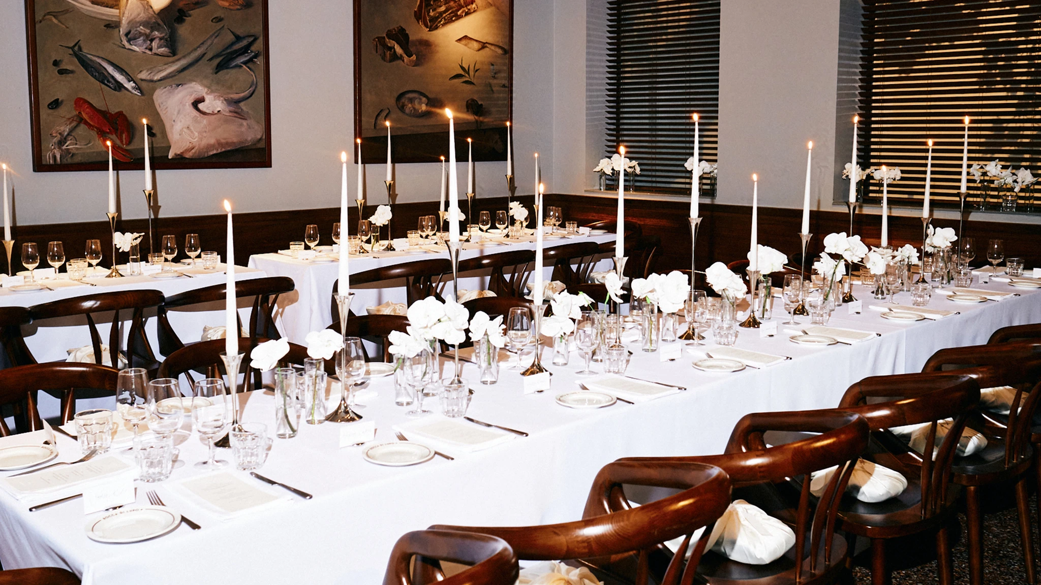 Table set with white tablecloths, white flowers and white candles