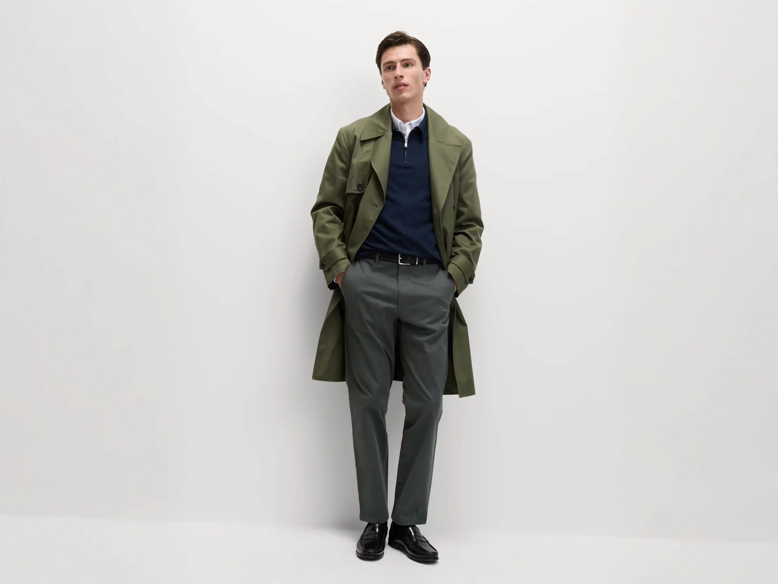 Man wearing grey regular fit chinos and a green overcoat