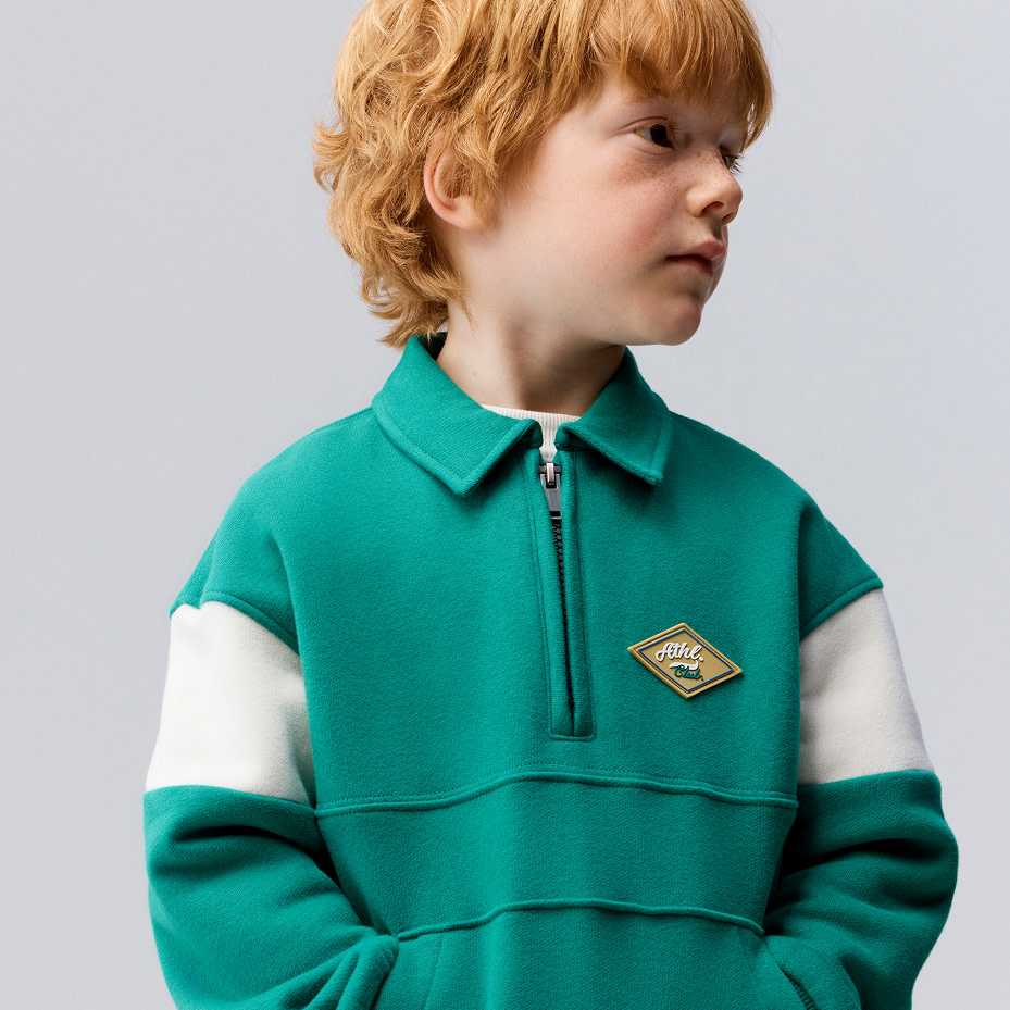 Boy wearing green half-zip sweatshirt