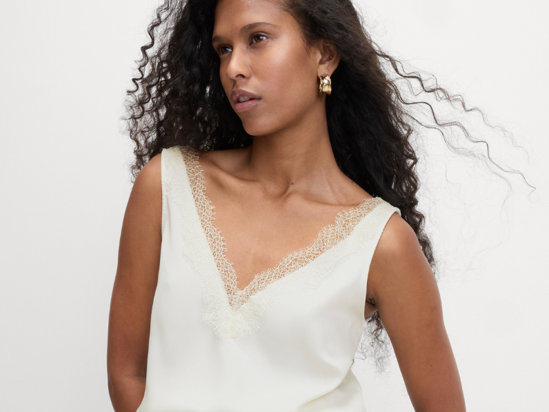 Woman wearing lace cami as part of underwear as outerwear trend 