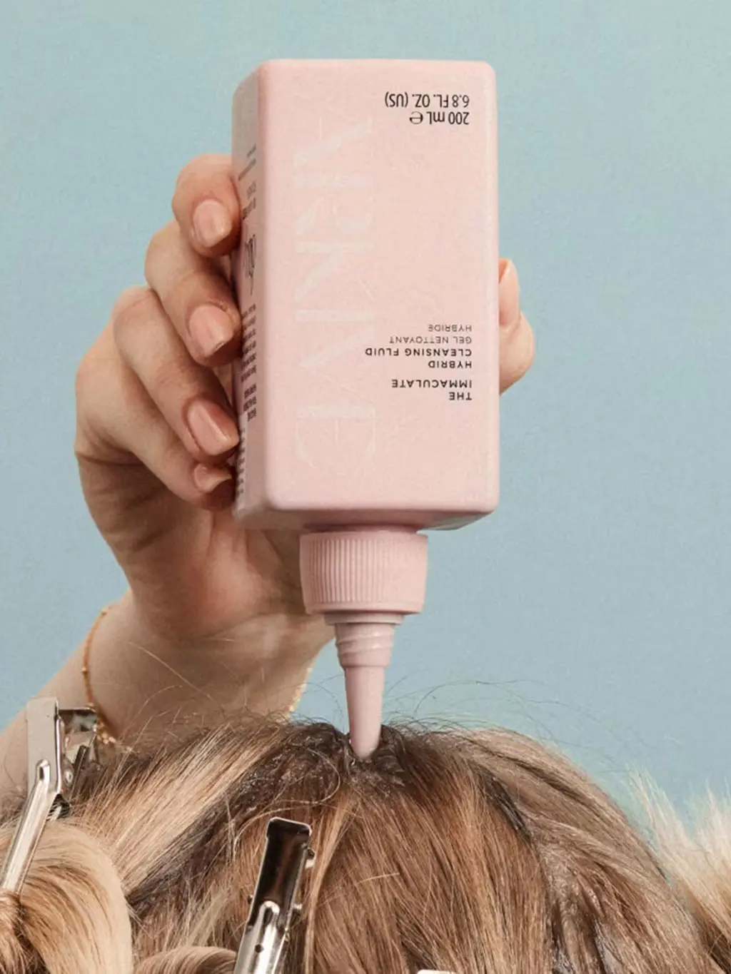 Woman applying Arkive's cleansing fluid to her hair