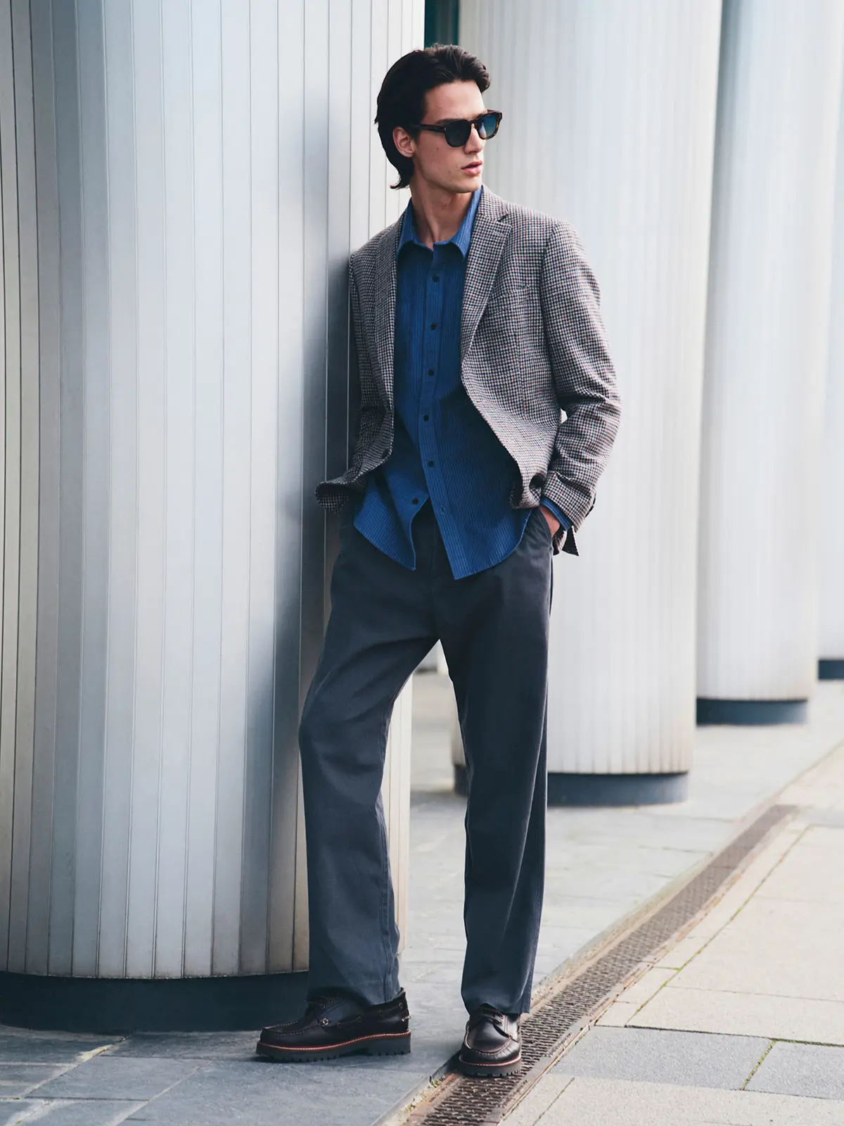 Man wearing grey blazer over blue shirt, with chinos and smart shoes 