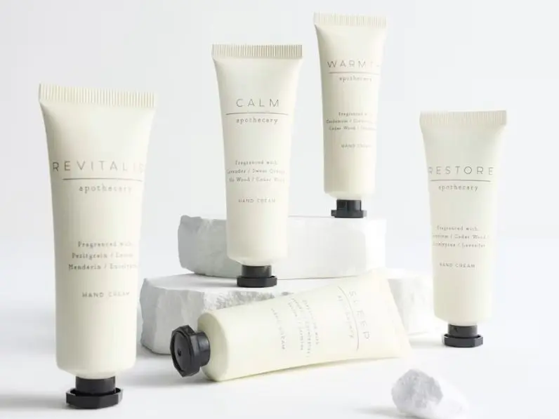 Five hand cream bottles placed on a flat surface