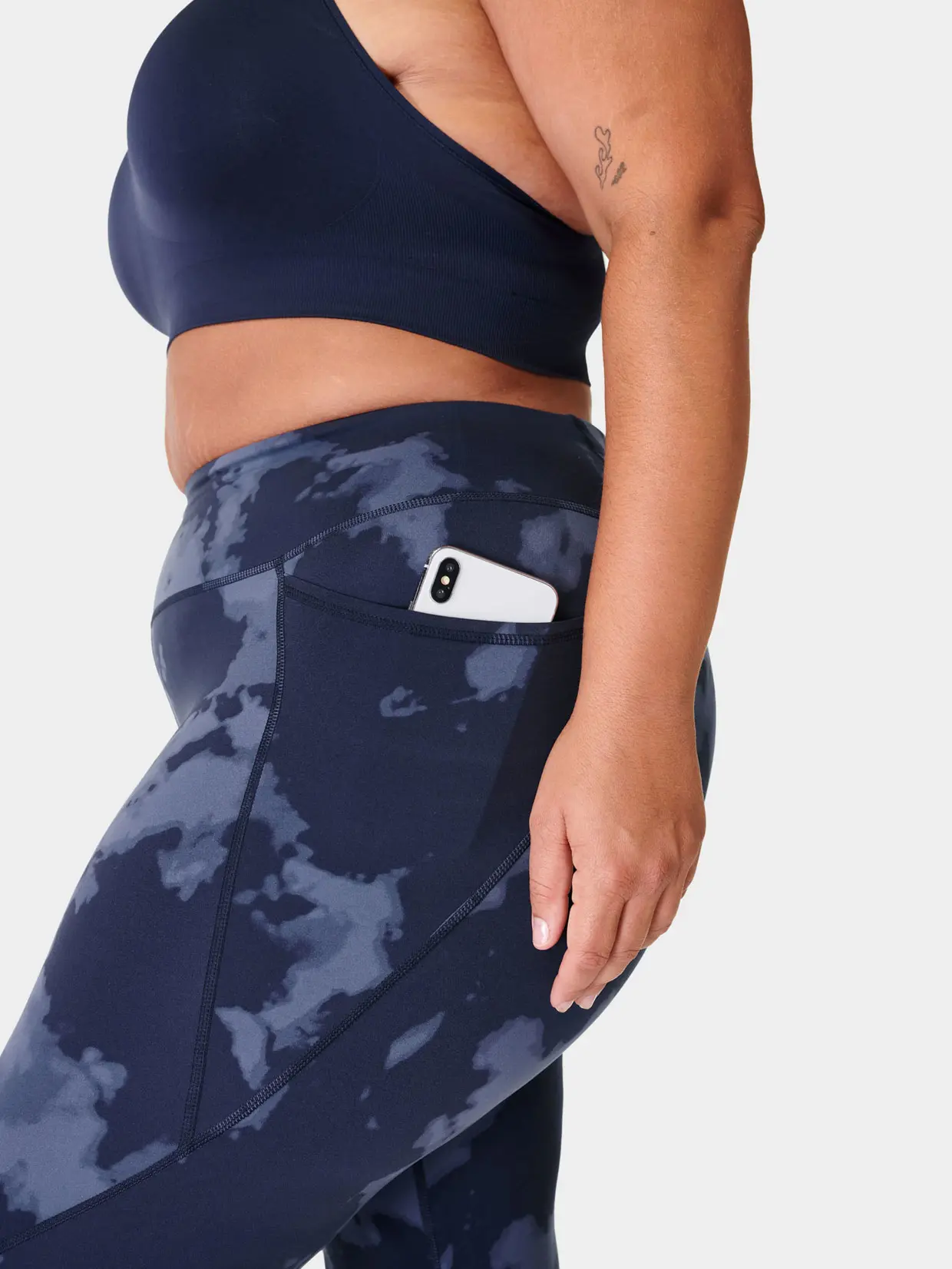 Woman wearing printed blue leggings and navy sports bra