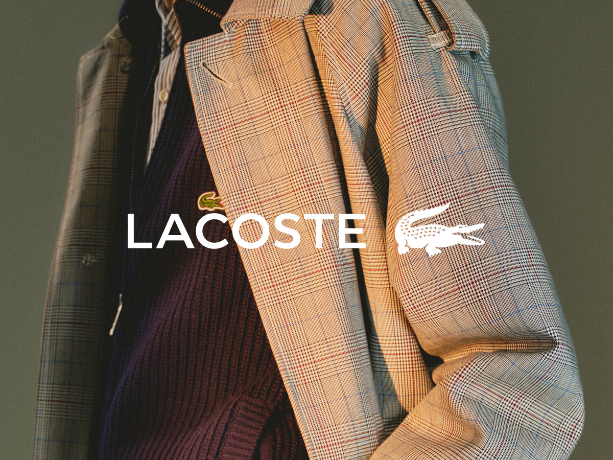 Man wearing checked Lacoste trench coat and navy sweater