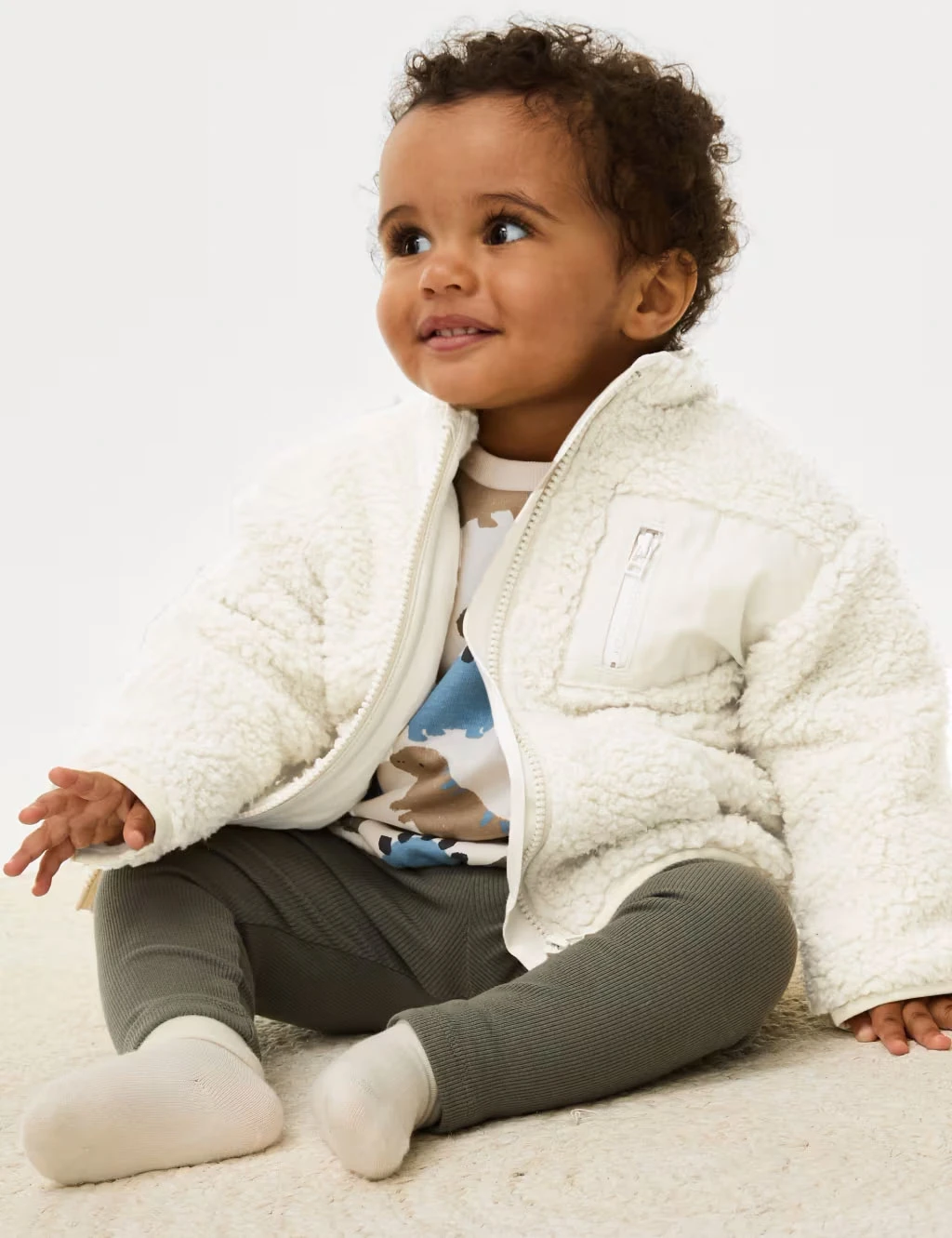 Baby wearing a borg jacket and khaki leggings