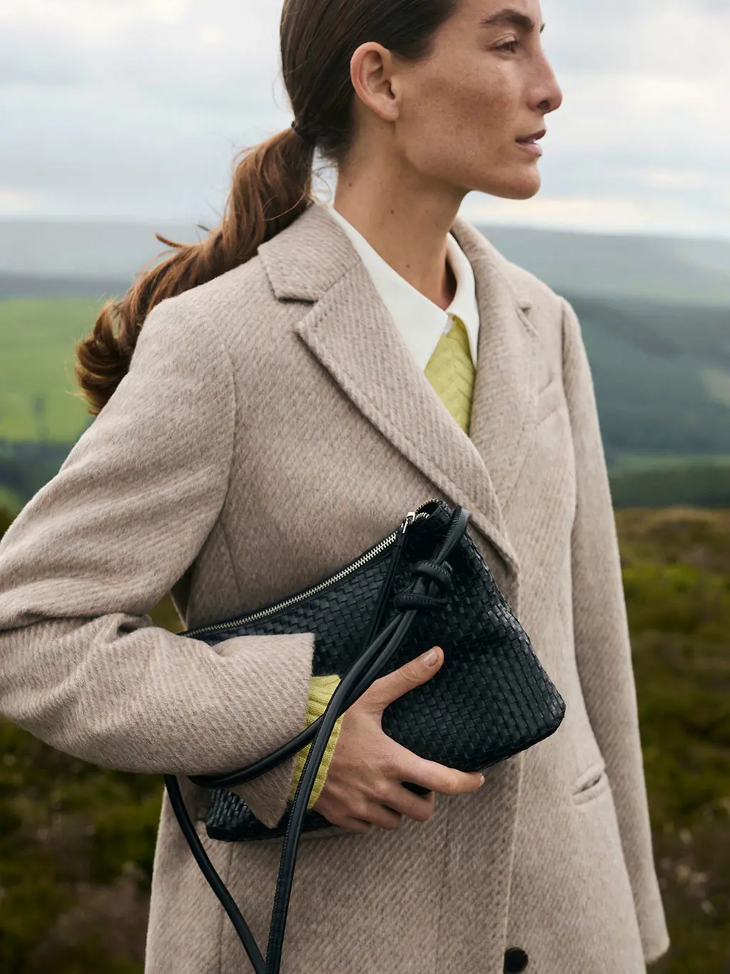 Woman in coat and green jumper
