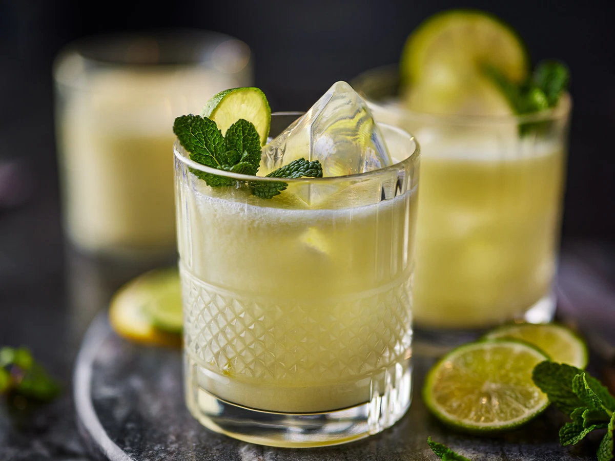 Three glasses of lemonade cocktail with mint and lime